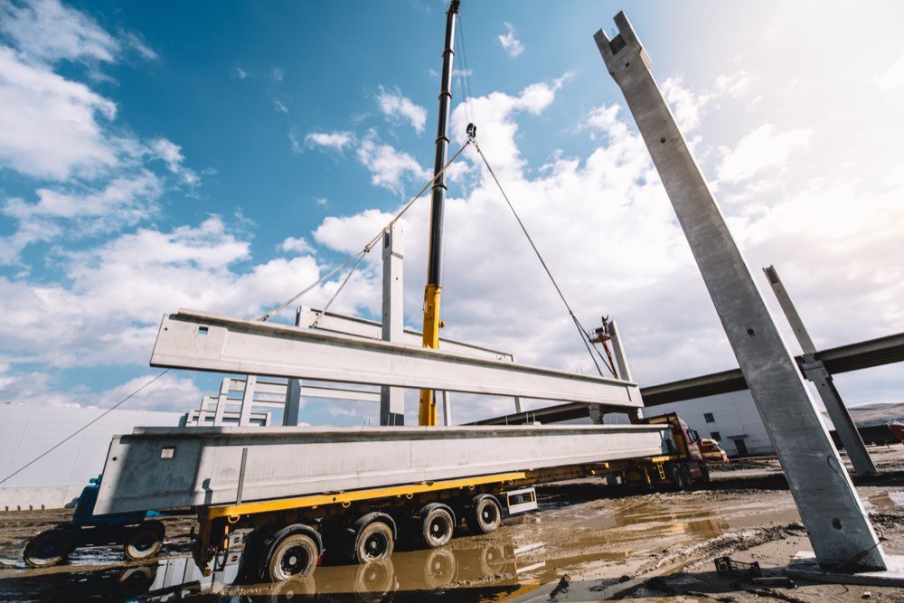 A crane lifting a precast concrete beam into place